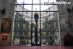 [P31] Teatre Museu Dalí din Figuerés: peretele de sticlă al sălii cupolei cu vedere spre curtea centrală. În dreapta se zărește tabloul ”Toreador halucinogen”, iar în stânga tabloul ”Sfântul Gheorghe eliberând un înger”. Se zăresc sub ele cele două casete cu portretele lui Hristos.  » foto by mariana.olaru
 - 
<span class="allrVoted glyphicon glyphicon-heart hidden" id="av436786"></span>
<a class="m-l-10 hidden" id="sv436786" onclick="voting_Foto_DelVot(,436786,12859)" role="button">șterge vot <span class="glyphicon glyphicon-remove"></span></a>
<a id="v9436786" class=" c-red"  onclick="voting_Foto_SetVot(436786)" role="button"><span class="glyphicon glyphicon-heart-empty"></span> <b>LIKE</b> = Votează poza</a> <img class="hidden"  id="f436786W9" src="/imagini/loader.gif" border="0" /><span class="AjErrMes hidden" id="e436786ErM"></span>