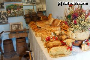 [P19] Pâini şi produse de panificaţie. În spate se observă două putini iar agăţate de perete mai multe fotografii şi tablouri. Pâinile au fost coapte în ziua de Paşte a anului 2012 iar fotografia a fost realizată în luna august.  » foto by Utube
 - 
<span class="allrVoted glyphicon glyphicon-heart hidden" id="av378733"></span>
<a class="m-l-10 hidden" id="sv378733" onclick="voting_Foto_DelVot(,378733,13024)" role="button">șterge vot <span class="glyphicon glyphicon-remove"></span></a>
<a id="v9378733" class=" c-red"  onclick="voting_Foto_SetVot(378733)" role="button"><span class="glyphicon glyphicon-heart-empty"></span> <b>LIKE</b> = Votează poza</a> <img class="hidden"  id="f378733W9" src="/imagini/loader.gif" border="0" /><span class="AjErrMes hidden" id="e378733ErM"></span>