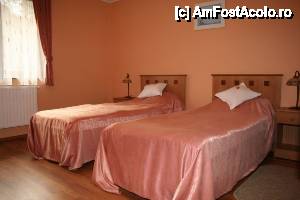 [P04 <small>[FOTO OFICIALĂ, DE PREZENTARE:] </small>] Pensiunea poate caza 44 persoane. LocaÅ£ia are 13 camere dotate la un nivel superior, respectiv 2 apartamente. Fiecare camerÄƒ este dotat cu baie proprie, TV cablu ÅŸi minibar.